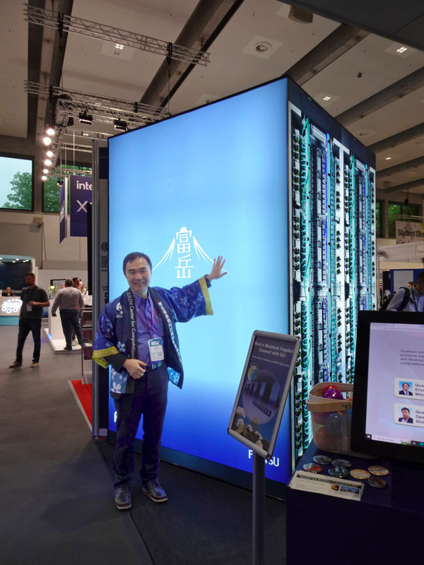 ドイツ ハンブルクで開催されたHPC(ハイパフォーマンス・コンピューティング)に関する国際学会「ISC2023」の展示会場に設置された巨大模型前で「富岳」の説明をするセンター長の松岡さん