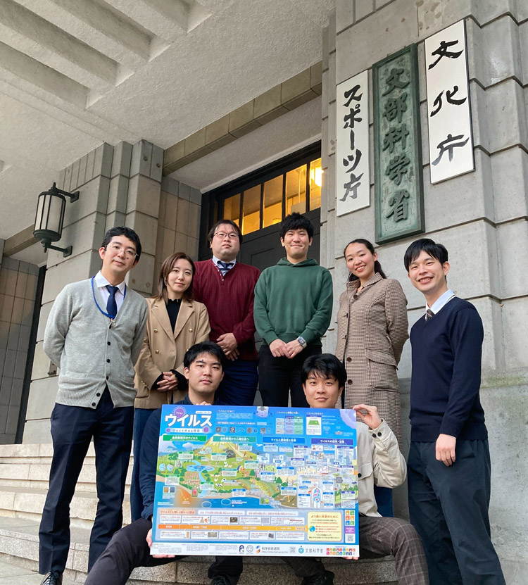 小嶋研究員(後方左から4番目)ら「ウイルス」ポスターの制作メンバー(一部)が文部科学省を訪ねた(小嶋研究員提供)