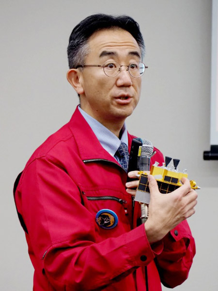 会見でスリムの模型を示しながら説明する坂井氏=25日、東京都千代田区