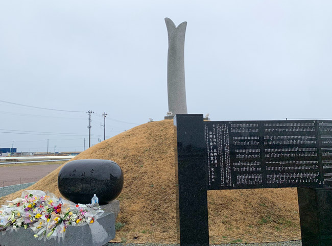 東日本大震災のメモリアル公園の祈りの広場に建てられた慰霊碑。空に伸びる「芽生えの塔」は津波高と同じ8.4メートル。多くの犠牲者を出した宮城県名取市閖上地区で亡くなった人の全員の名前も刻まれている(2023年3月13日撮影)